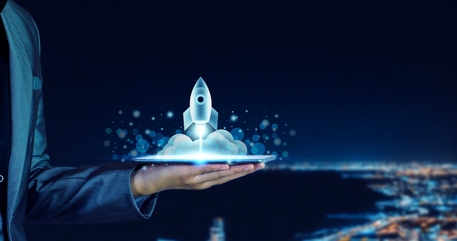 Startup business concept. Businessman holding a tablet, rocket launching and soar flying out from screen, starting a business, growing business, modern technology, hologram, network connection.